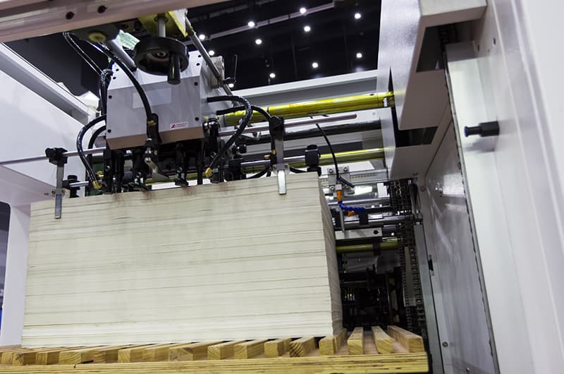 Stack of board feeding into a converting machine on the production floor