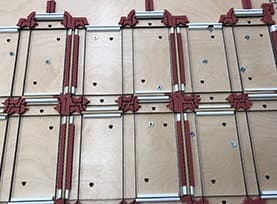 Steel rule cutting die with red ejection rubber set around a repeating carton nest