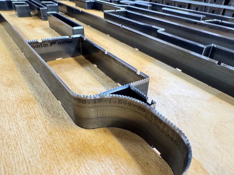 Serrated steel rule bent to a curved profile and set into a plywood die board