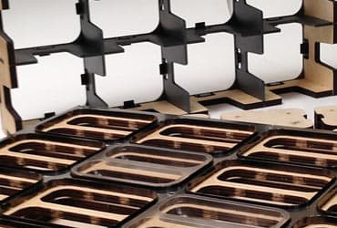 Thermoform trim tooling with formed tray cavities in the foreground and a stripping comb behind