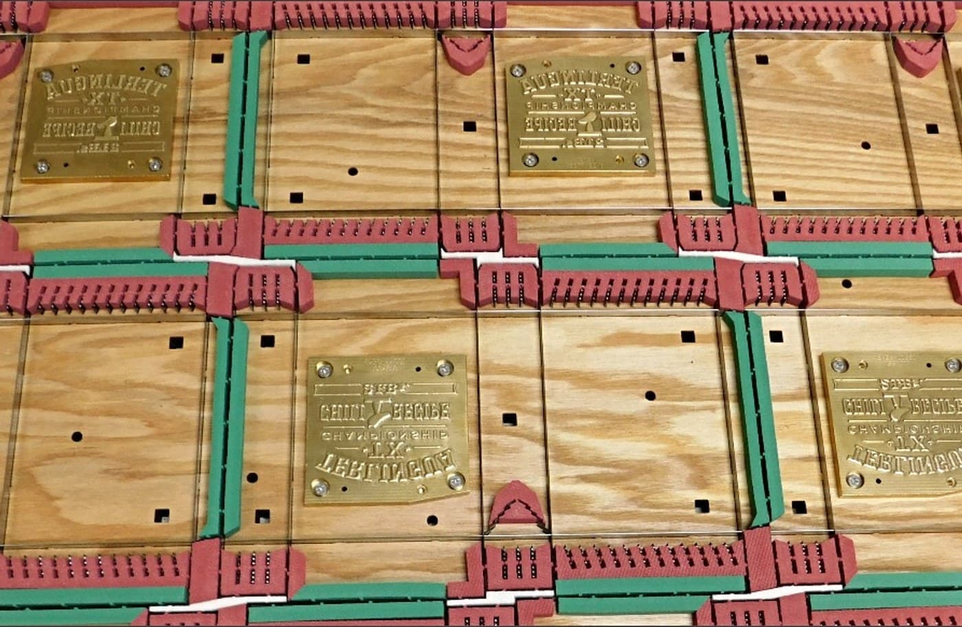 Finished dies on the bench, brass plates set into plywood between rule and rubber